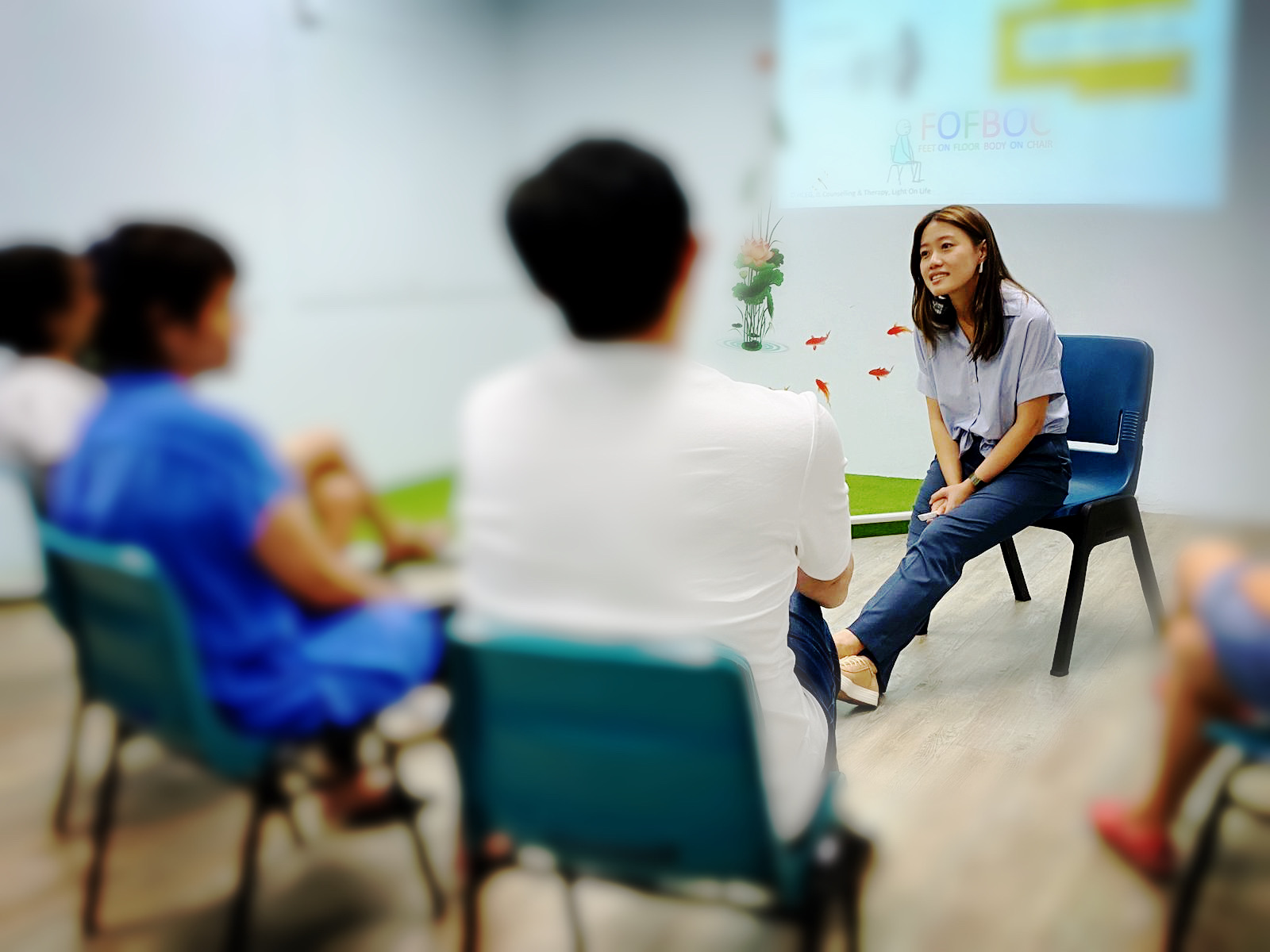 Erin Lee leading a mindfulness coaching session, sitting with a small group in conversation.